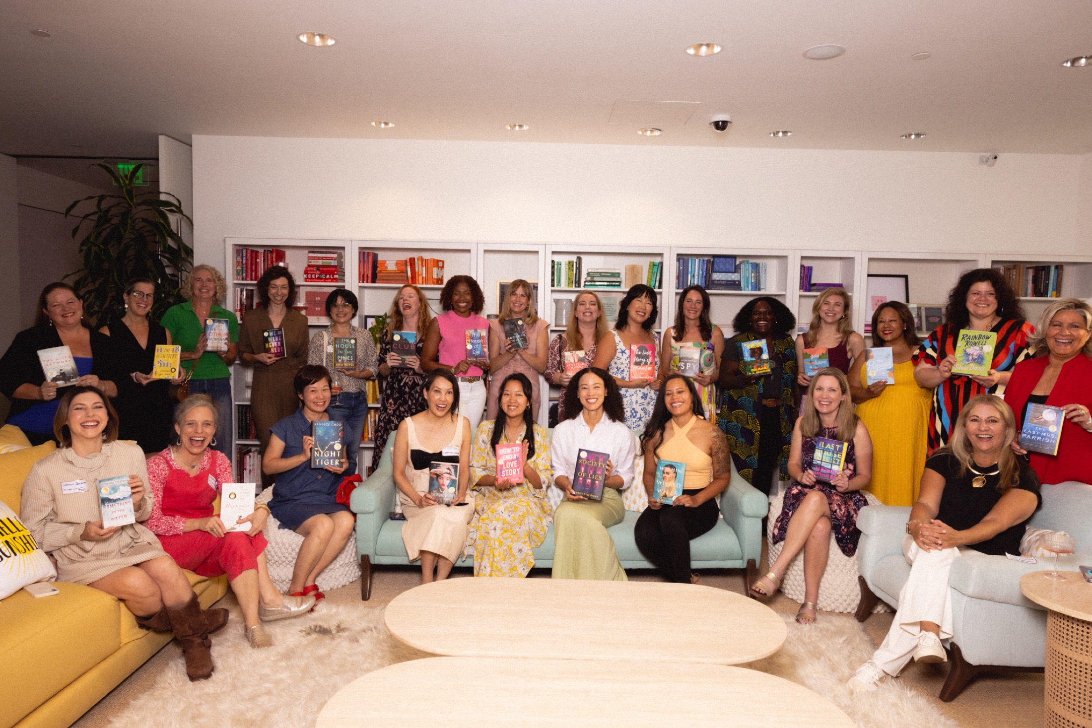 Reese’s Book Club authors gathered together holding their book picks