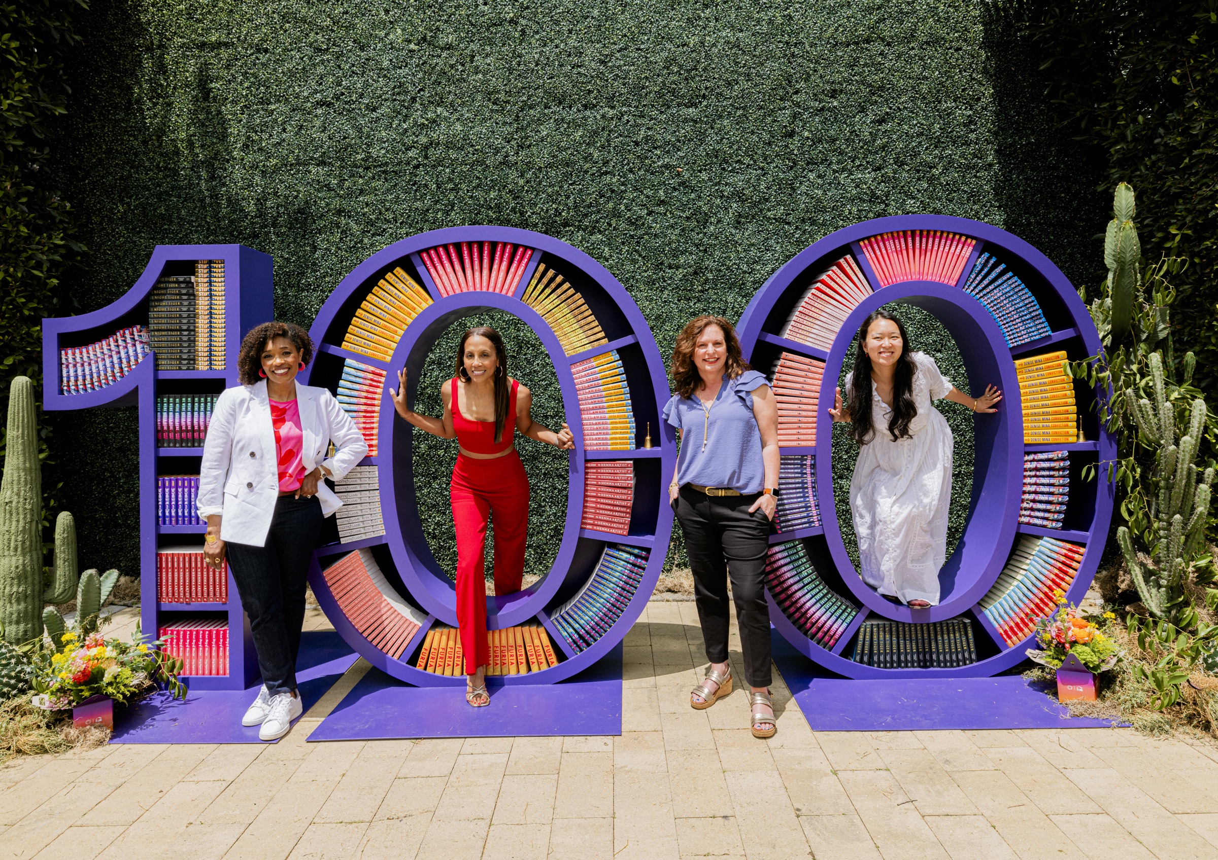 Guests celebrating beside a giant 100 installation filled with Reese’s Book Club picks
