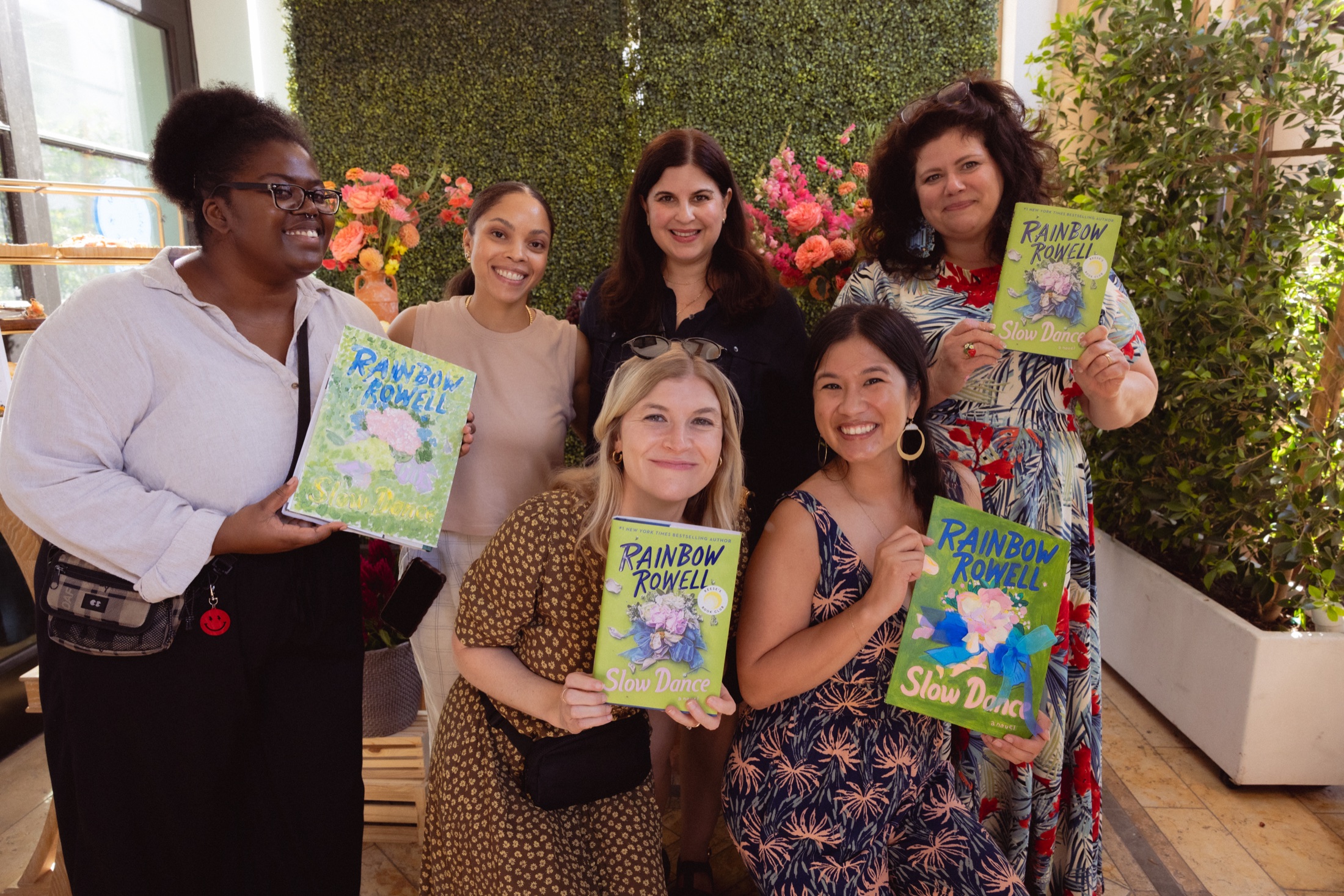 The Read, Sip, Repeat team and guests holding their finished Slow Dance paintings