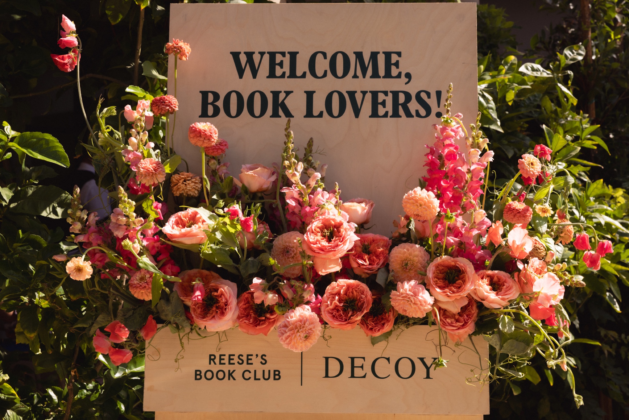A flower-filled welcome sign for Reese’s Book Club and Decoy Wine
